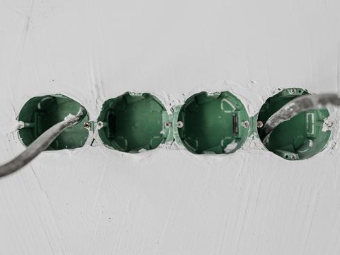 Boîtes d'encastrement alignées dans un mur enduit avant appareillage