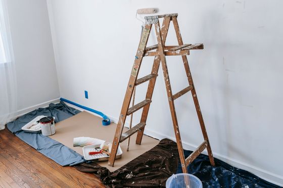 Pièce vidée et protégée, escabeau et bâche avant travaux de rénovation